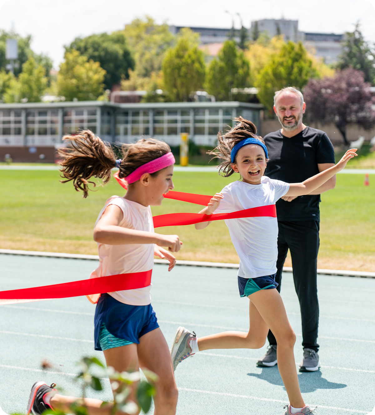 Girls racing on track, crossing finish line