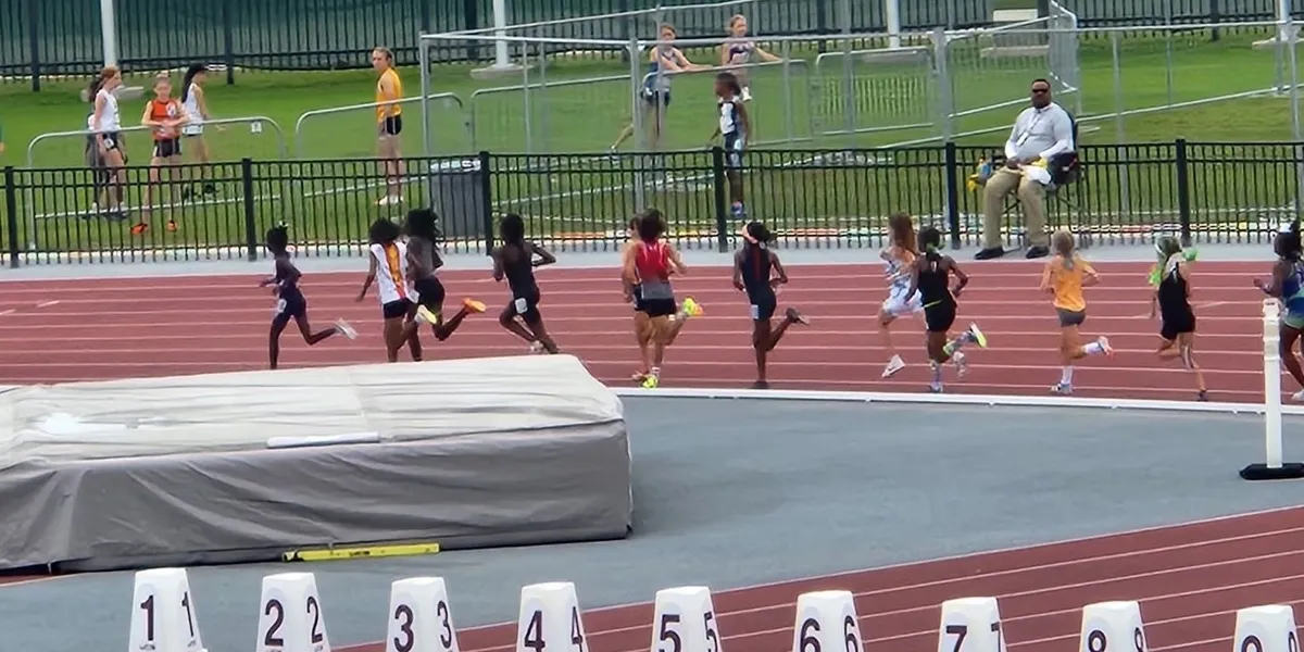 Children running on outdoor track race.
