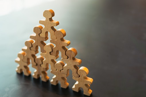 Wooden figures stacked in a pyramid shape.